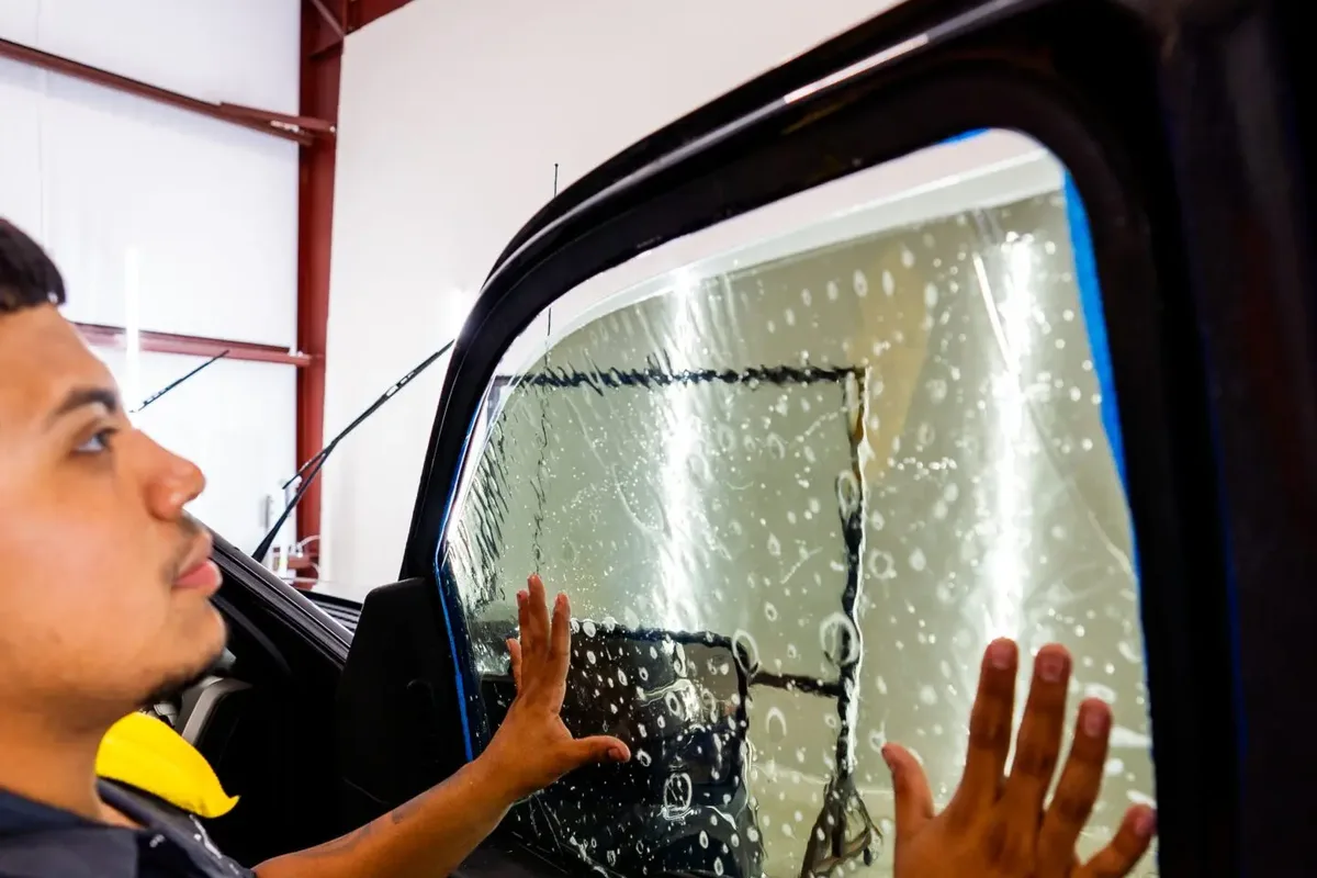 Window tint film being installed on a car door glass